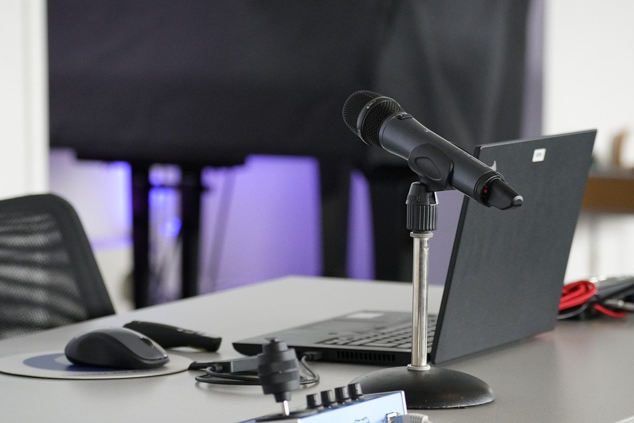 A podcast setup: a laptop and a microphone on a desktop