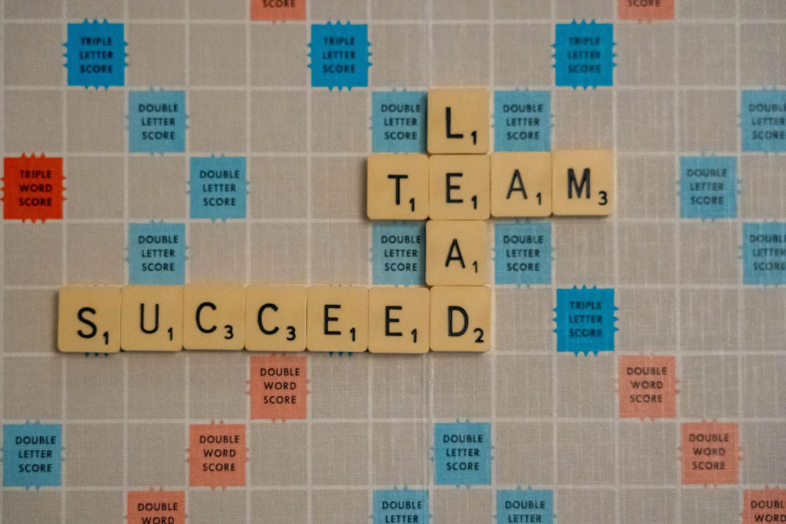 A puzzle game with words "Team", "Lead", and "Succeed"