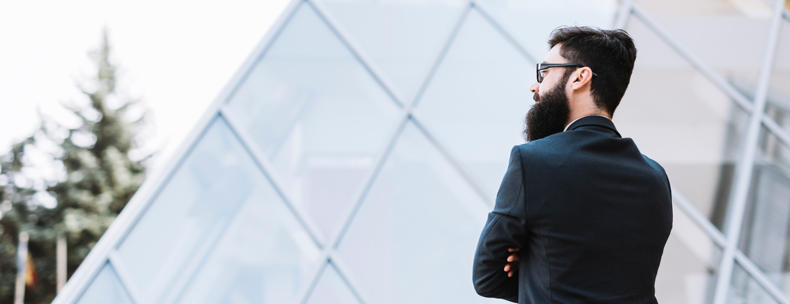 A bearded man in a suit looking thoughtfully into the distance, symbolizing thought leadership.