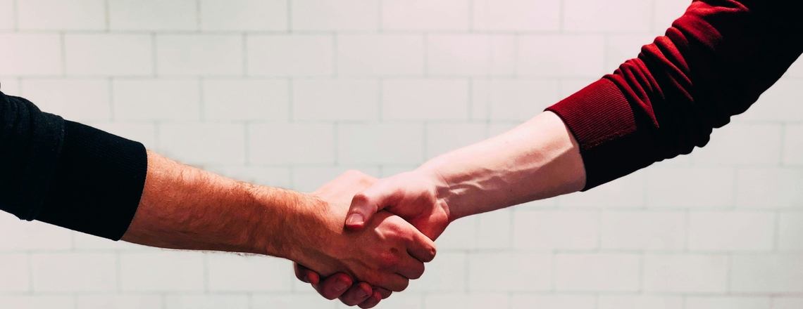 Two people shaking hands as a symbol of thought leadership collaboration.