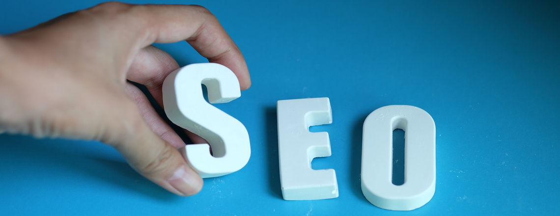 Hand arranging letters to form the word ‘SEO,’ representing SEO strategies for digital marketing.